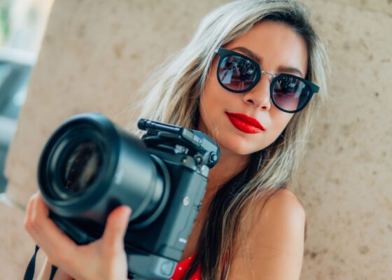 Video portrait, a girl holding professional photography camera in palm beach